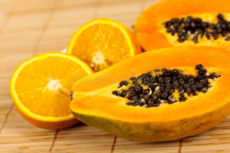 Half papaya on a wooden background.