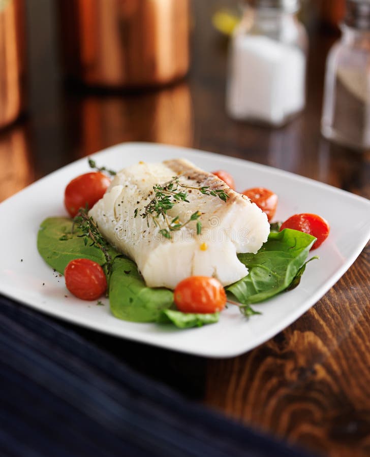 Halibut with spinach, cherry tomatoes and thyme royalty free stock images