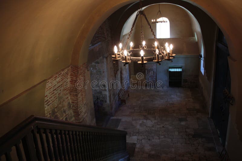 Hall av den forntida byggnaden med den träräcke, järnljuskronan och väggar för röd tegelsten arkivbilder Hall av den forntida byggnaden med den träräcke, järnljuskronan och väggar för röd tegelsten arkivbilder