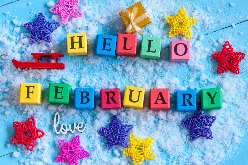 Hallo Februar geschrieben auf Farbhölzerne Spielzeugwürfel auf hellem Hintergrund mit Schnee