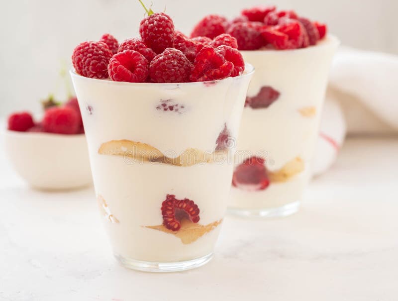 Hallonefterrätten, ostkaka, hallontiramisu, förspiller tiden, mousse i ett exponeringsglas på en vit bakgrund royaltyfria foton Hallonefterrätten, ostkaka, hallontiramisu, förspiller tiden, mousse i ett exponeringsglas på en vit bakgrund royaltyfria foton