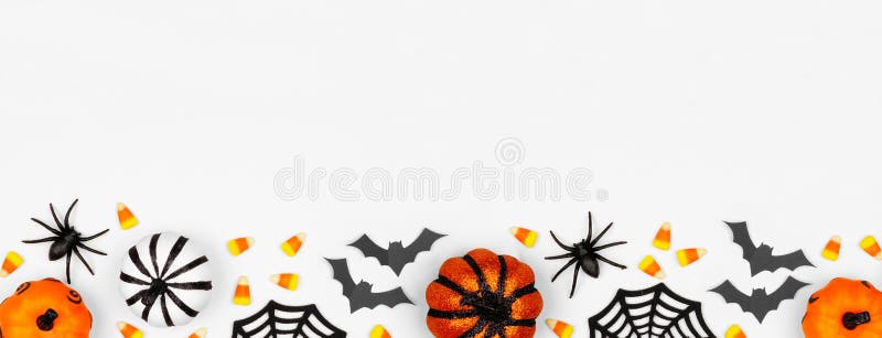 Halloween bottom border banner of pumpkins, candy and decor. Flat lay over a white background with copy space. Halloween bottom border banner of pumpkins, candy and decor. Flat lay over a white background with copy space