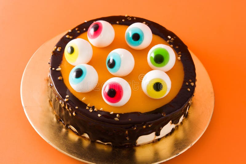 Halloween cake with candy eyes decoration on wooden table. Close