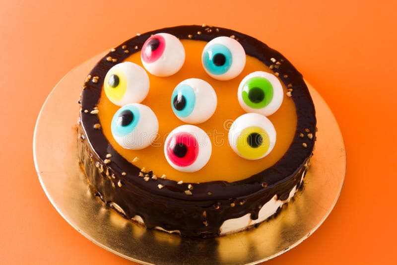 Halloween Cake with Candy Eyes Decoration on Orange Background. Stock