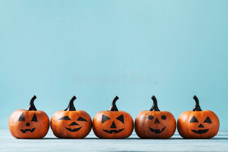 Halloween card with funny pumpkin heads on turquoise background.