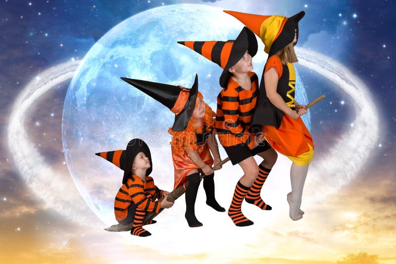Halloween.The children of witches and wizards fly on broomsticks across the sky.Beautiful children in Halloween costumes. stock photo Halloween.The children of witches and wizards fly on broomsticks across the sky.Beautiful children in Halloween costumes. stock photo