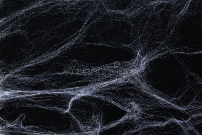 Halloween concept. White fake white wool spiderweb on black background as option for table or photo zone decor. Halloween concept. White fake white wool spiderweb on black background as option for table or photo zone decor