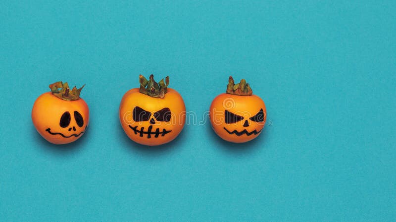 Halloween concept. Three scary pumpkins on an azure background with space for text, flat style