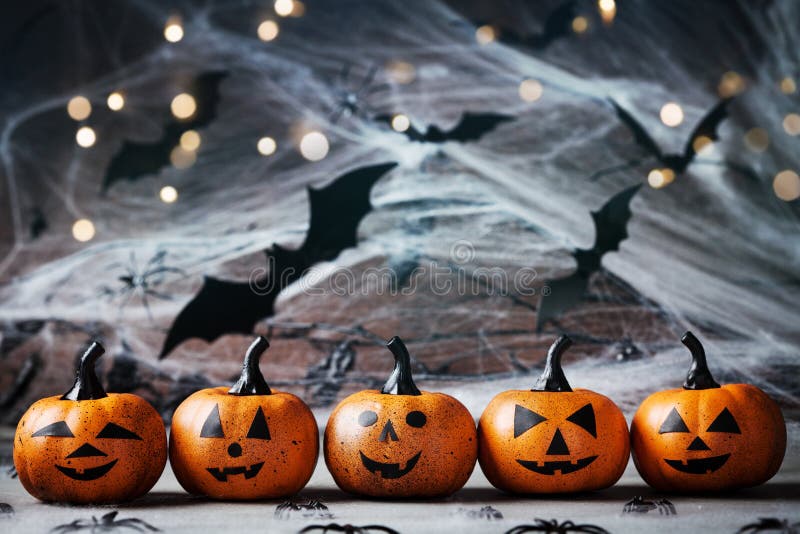 Halloween decoration with funny pumpkin heads, spider, web and flying bat on mystical background.