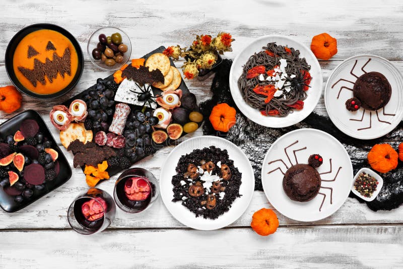 Halloween dinner party table scene over a white wood background