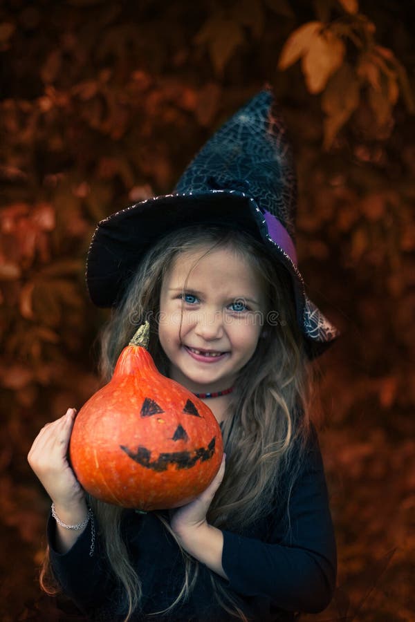 Halloween. the Girl Laughs and Holds a Pumpkin in Her Hands. Stock ...