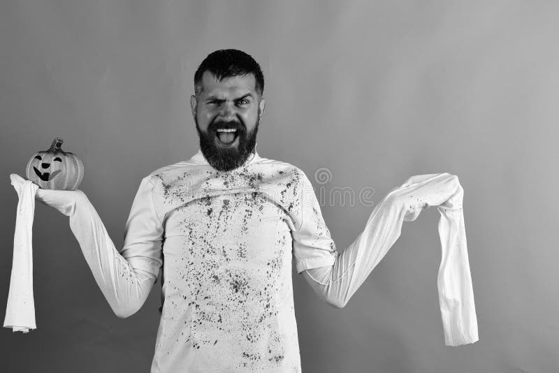 Halloween and happy holiday concept. Man with cheerful face. Expression on green background, copy space. Halloween character in white long sleeved ghost costume stock photography Halloween and happy holiday concept. Man with cheerful face. Expression on green background, copy space. Halloween character in white long sleeved ghost costume stock photography