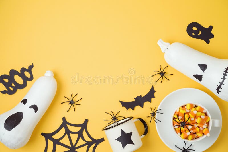 Halloween holiday background with jack o lantern pumpkin, candy corn and decorations. View from above. Flat lay