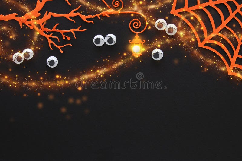 Halloween holiday concept. haunted forest with eyes staring out of the darkness over black background. Top view, flat lay.