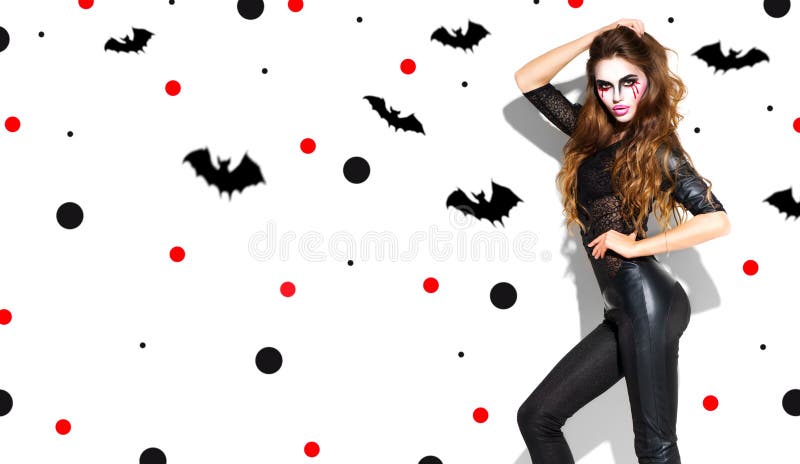Halloween. Holiday party girl. Beautiful young woman with bright vampire makeup and long hair posing in witches costume stock images Halloween. Holiday party girl. Beautiful young woman with bright vampire makeup and long hair posing in witches costume stock images