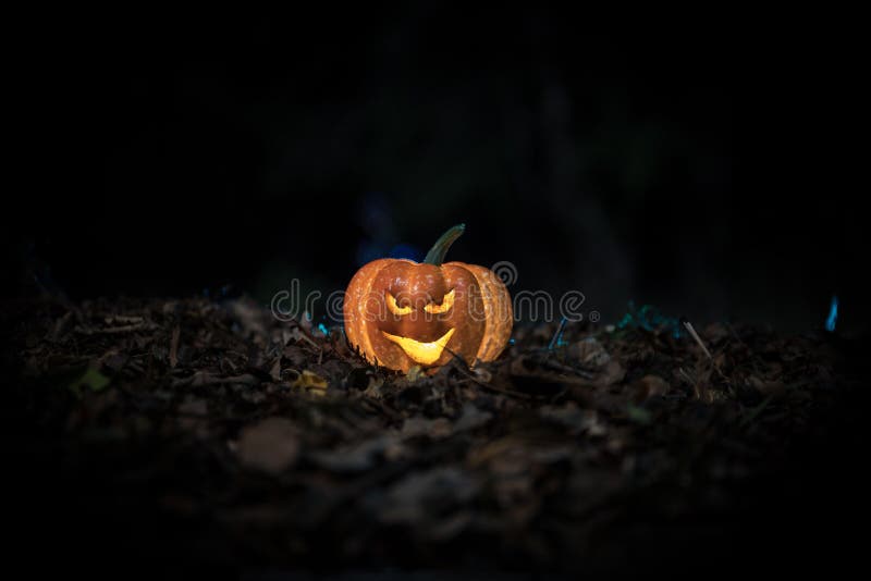 halloween jack-o-lantern on autumn leaves. Scary Halloween Pumpkin looking through the smoke. Glowing stock images halloween jack-o-lantern on autumn leaves. Scary Halloween Pumpkin looking through the smoke. Glowing stock images