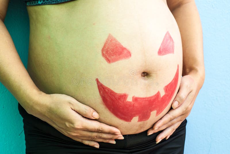 Halloween malte auf Bauch der schwangeren Frau stockfotografie Halloween malte auf Bauch der schwangeren Frau stockfotografie