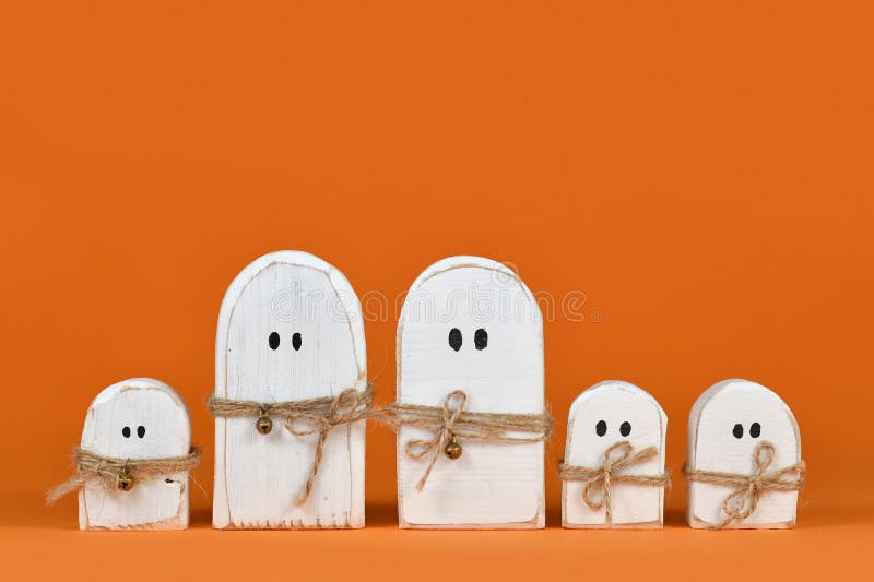 Halloween-Ornamente aus Holz in einer Reihe auf orangefarbenem Hintergrund lizenzfreie stockfotos