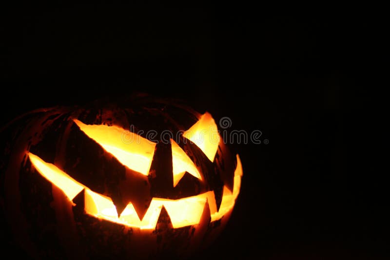 Halloween pumpkin glowing in the dark room. (Jack-o'-lantern)