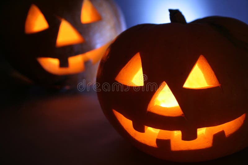 Double Halloween pumpkin head. Cold back light, scary smiling, warm light inside head.