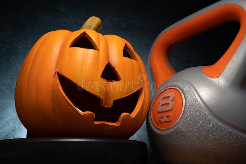 Halloween pumpkin decoration and heavy gym kettlebell.