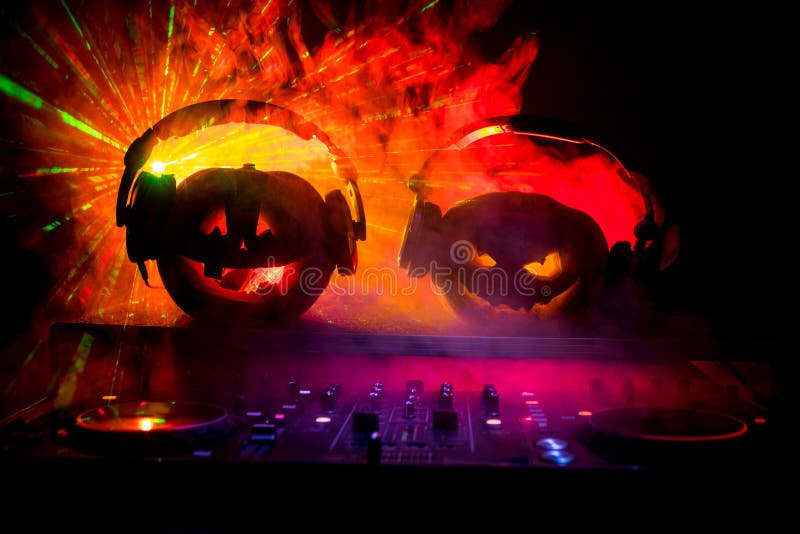 Halloween pumpkin on a dj table with headphones on dark background with copy space. Happy Halloween festival decorations and music royalty free stock images Halloween pumpkin on a dj table with headphones on dark background with copy space. Happy Halloween festival decorations and music royalty free stock images