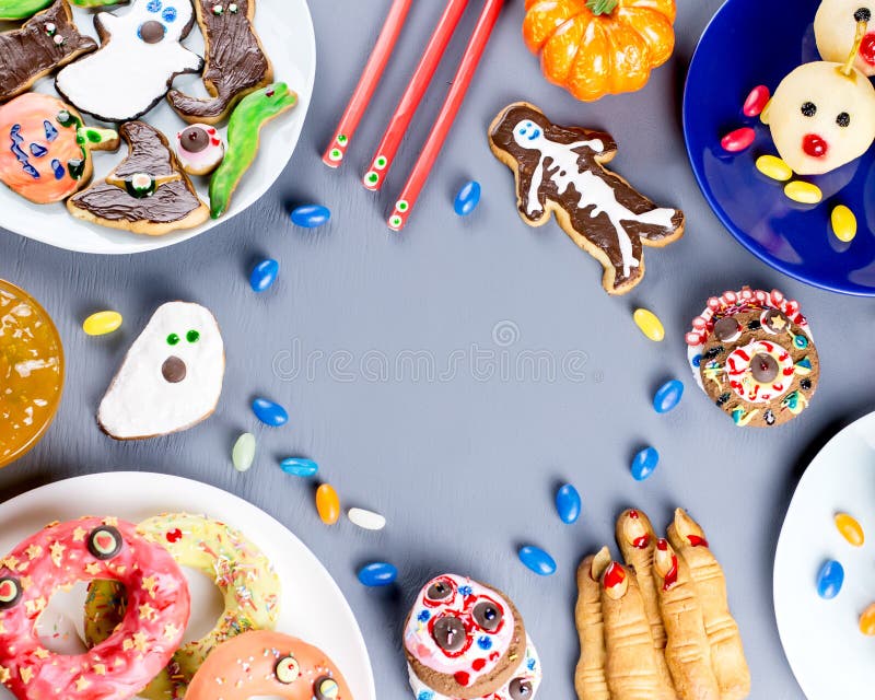 Halloween sweet treats, party food concept. Scary cookies, monster biscuits and fruits on grey background. royalty free stock photos Halloween sweet treats, party food concept. Scary cookies, monster biscuits and fruits on grey background. royalty free stock photos