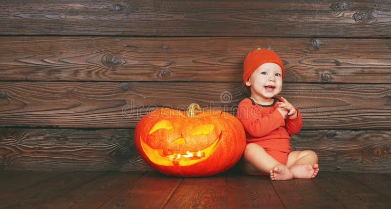 halloween Szczęśliwy śmieszny dziecko z dyniową dźwigarką na drewnianym zdjęcia royalty free halloween Szczęśliwy śmieszny dziecko z dyniową dźwigarką na drewnianym zdjęcia royalty free