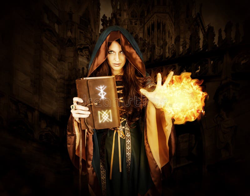 Halloween witch holding magical book with runes making magic