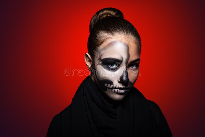 Halloween. young beautiful girl with skeleton makeup on her face. Girl on a bright red background royalty free stock photos Halloween. young beautiful girl with skeleton makeup on her face. Girl on a bright red background royalty free stock photos