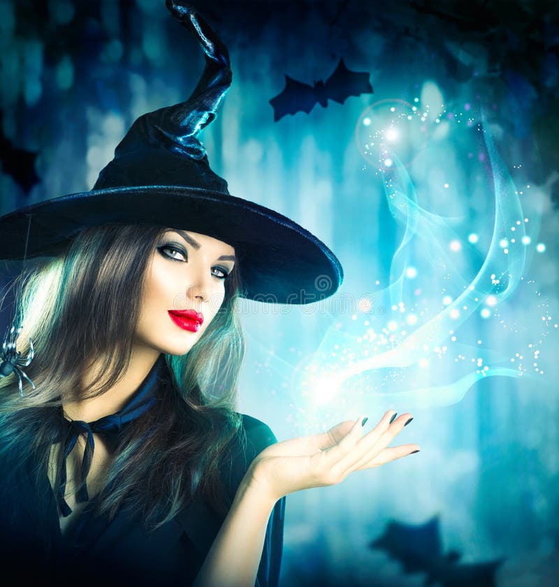 Halloweenowa czarownica trzyma magicznego światło