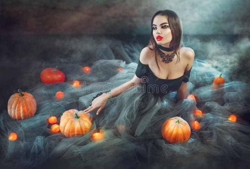 Halloweenowa czarownica z baniami i magii światłami