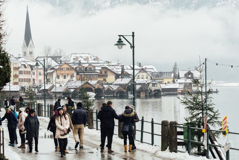 HALLSTATT, AUSTRIA - ENERO DE 2019: turistas que caminan a lo largo de la costa del lago en la ciudad vieja fotos de archivo HALLSTATT, AUSTRIA - ENERO DE 2019: turistas que caminan a lo largo de la costa del lago en la ciudad vieja fotos de archivo