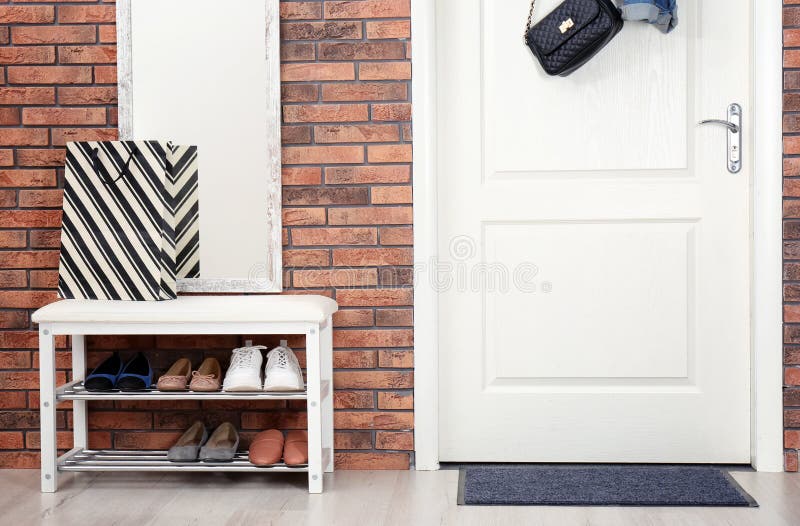 Hallway interior with shoe rack, mirror and mat