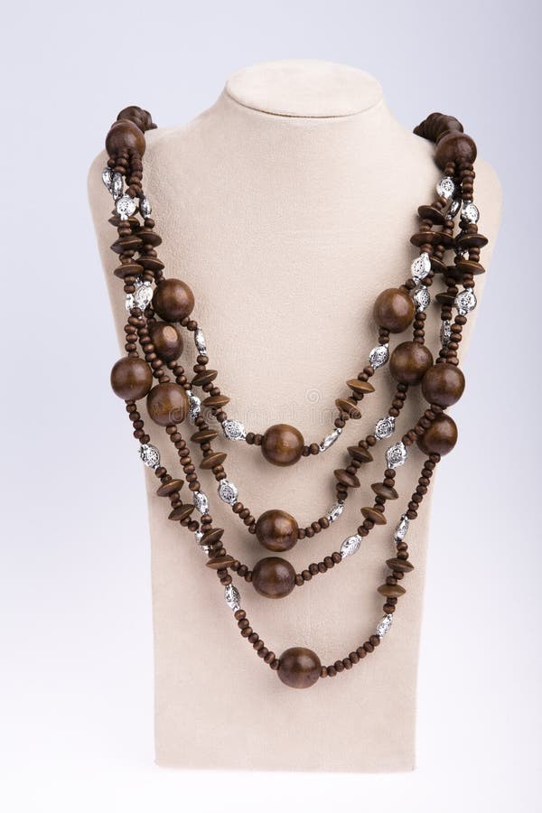 Beads of wooden made necklace with self-standing display on white background. Beads of wooden made necklace with self-standing display on white background