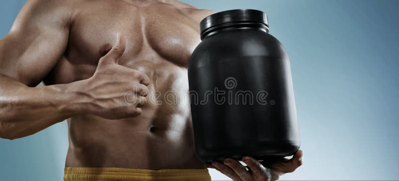 Halterofilista forte que guarda um frasco plástico com uma proteína seca e que mostra o gesto imagem de stock Halterofilista forte que guarda um frasco plástico com uma proteína seca e que mostra o gesto imagem de stock