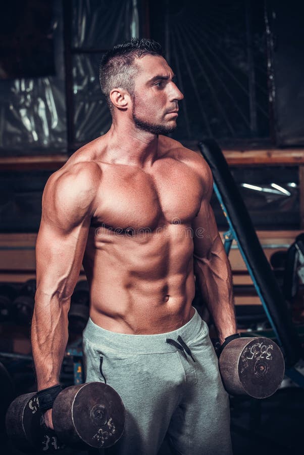 Halterofilista muscular que faz exercícios com pesos fotografia de stock Halterofilista muscular que faz exercícios com pesos fotografia de stock