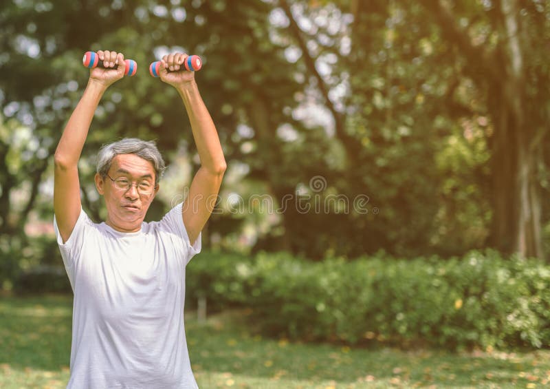 Haltère de levage d'homme mûr en parc image stock Haltère de levage d'homme mûr en parc image stock
