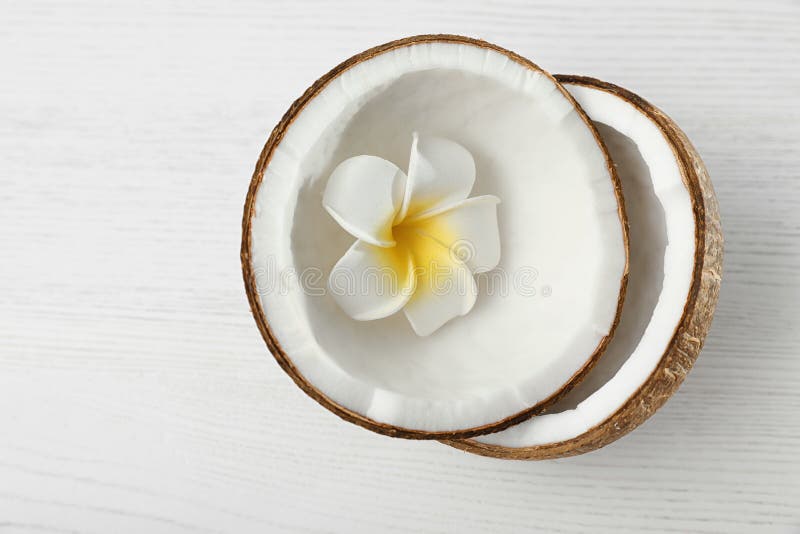 Halves of coconut and flower on white  background