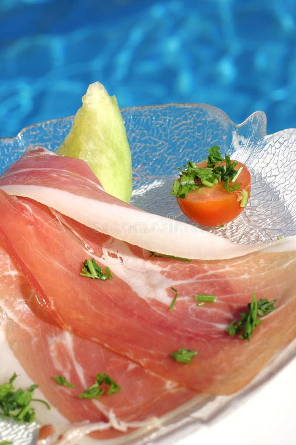 Italiano curtido jamón sandía sobre el mesa más cercano nadar piscina.