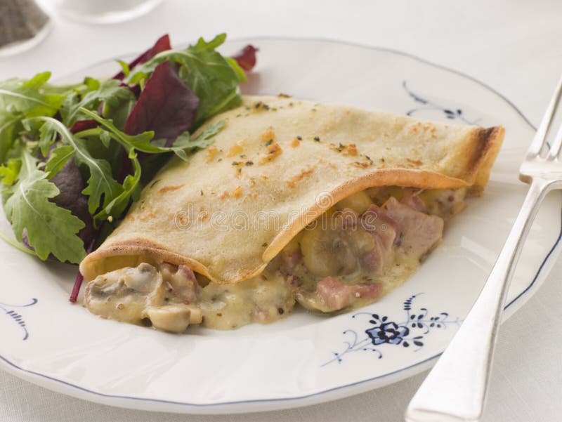 Savoury Pancake filled with Ham Cheese and Mushrooms with dressed salad. Savoury Pancake filled with Ham Cheese and Mushrooms with dressed salad