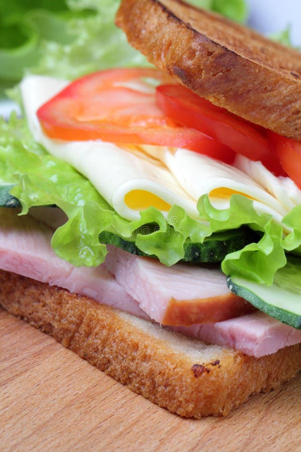 Ham, sla, plakken van kaas, tomaten, op een scherpe raad stock fotografie Ham, sla, plakken van kaas, tomaten, op een scherpe raad stock fotografie