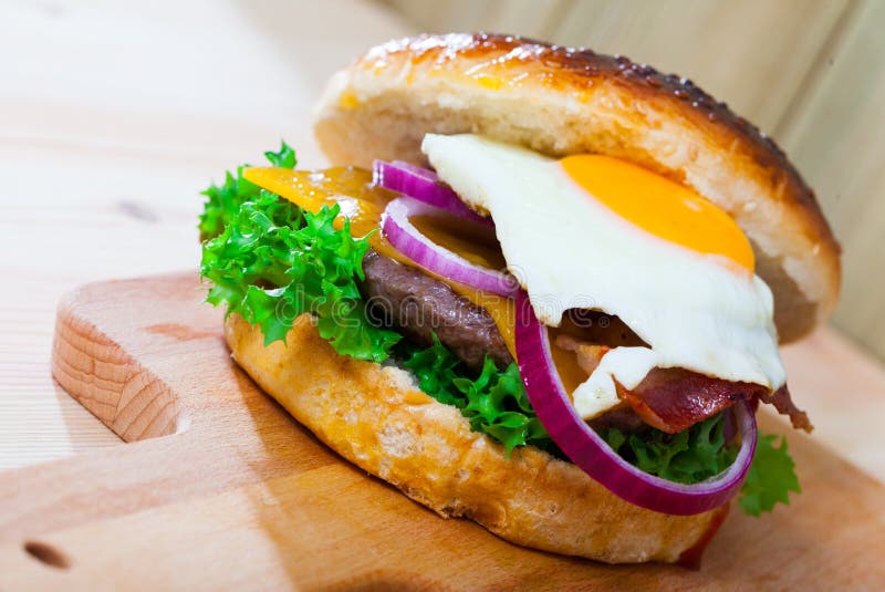 Hamburger with Beef Patty, Cheese, Fried Egg and Lettuce Stock Photo