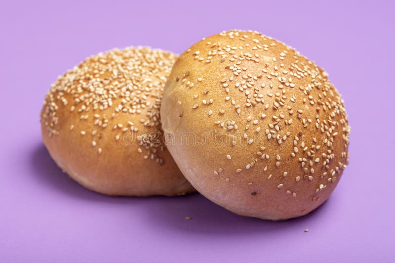 Hamburger buns isolated on a purple color. Homemade bread buns with sesame