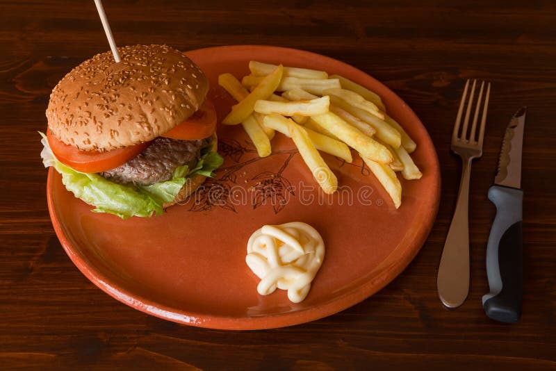 Hamburger Fried Potatoes and Mayonnaise on an Earthenware Plate Stock