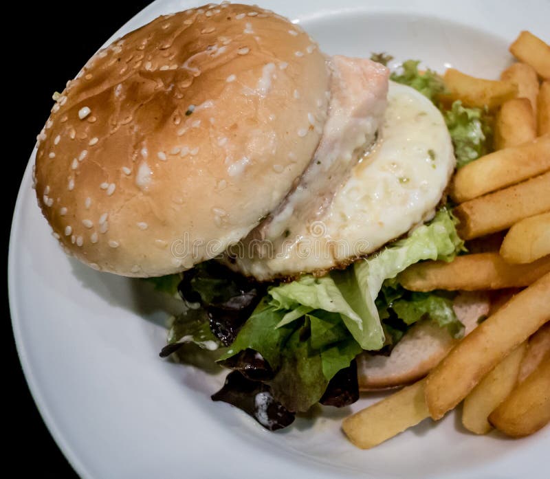 Hamburger met gefrituurde aardappel stock afbeelding