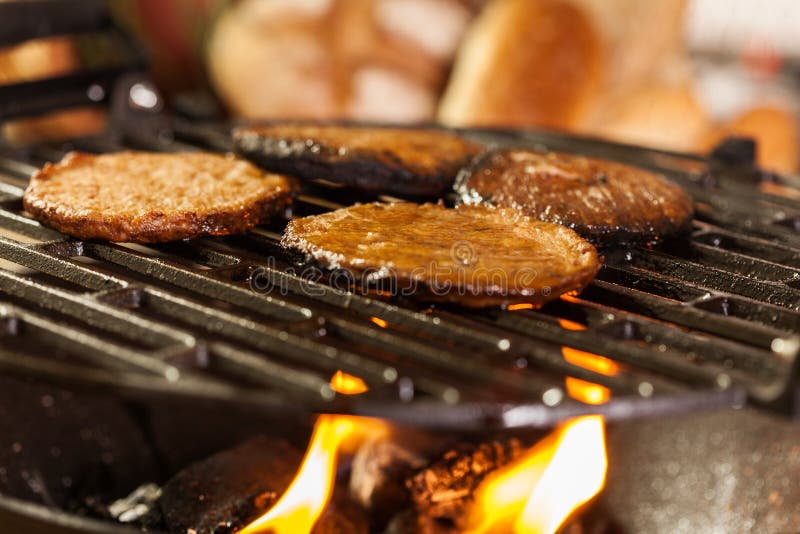 Hamburger Patties on a Grill with Fire Under Stock Photo Image of