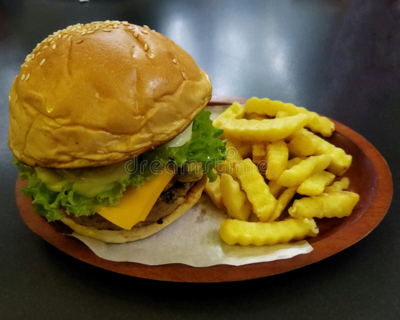 A Hamburger and Potato Chips on a Plate on a Table Stock Image Image