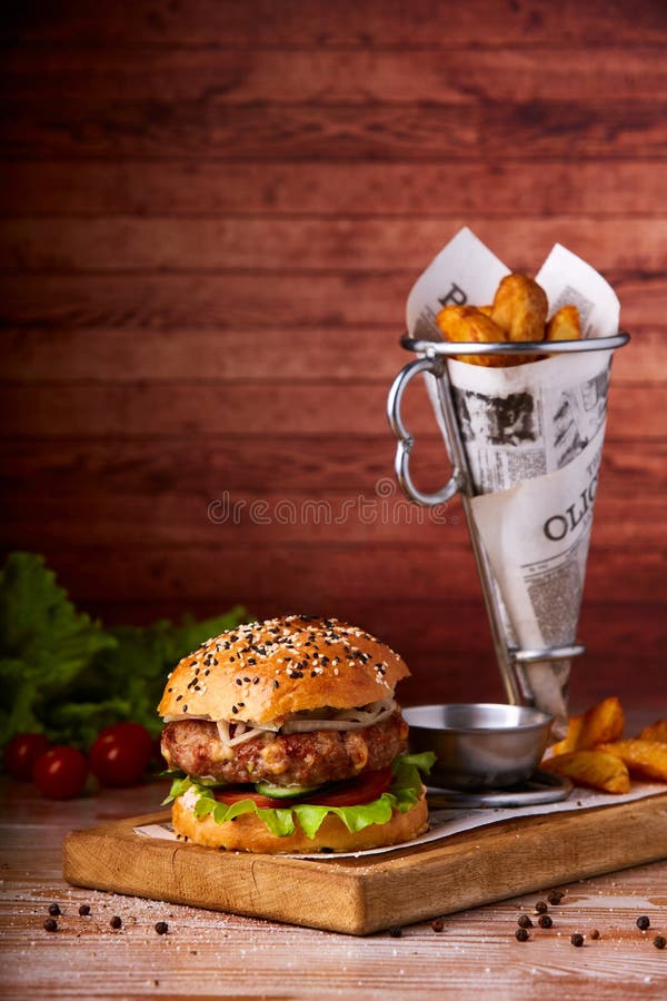 Hamburger słuzyć na drewnianych deskach Domowej roboty hamburger z sałatą i serem obrazy royalty free Hamburger słuzyć na drewnianych deskach Domowej roboty hamburger z sałatą i serem obrazy royalty free