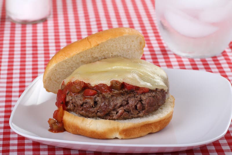 Hamburger topped with melted cheese and salsa